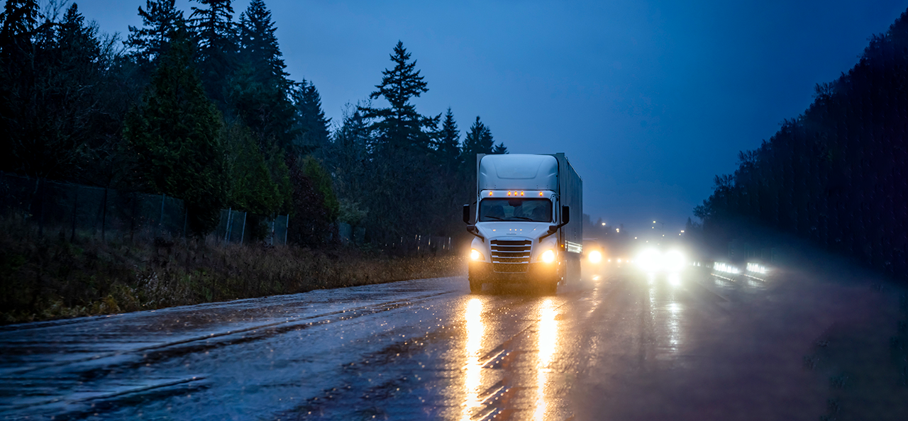 Semi-truck driving in the rain at night