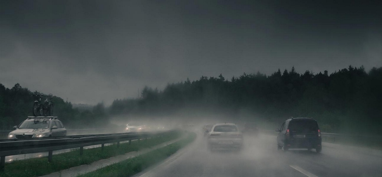 Cars driving down a raining highway